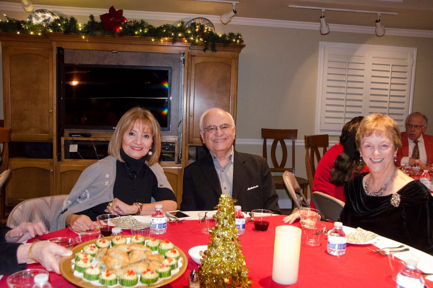 Photo of three people at a holiday party